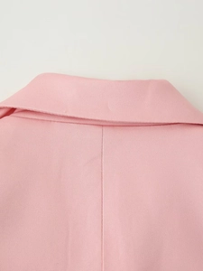 Close-up of the back collar and pink fabric texture of the women's suit jacket
