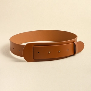 Macro view of brown leather wide waist belt with golden metal eyelets on textured background