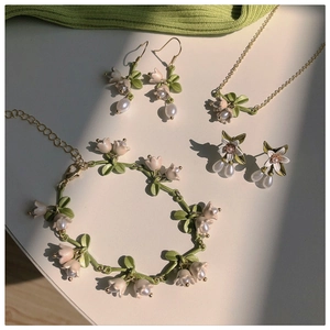 Detailed set of lily of the valley jewelry with pink pearls and green enamel leaves