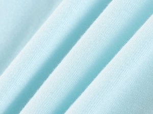 Close-up of light blue modal fabric texture showing fine knit details and soft folds
