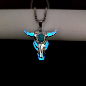 Luminous bull skull pendant with turquoise stone glowing blue in dark environment