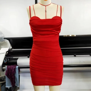 Détail de la robe rouge en mesh drapé montrant le tissu brillant et la coupe moulante