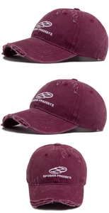 Détail de la casquette bordeaux délavée avec broderie vintage et texture coton déchirée