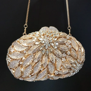 Detail of gold leaf flower evening clutch bag with sparkling rhinestones and metal chain