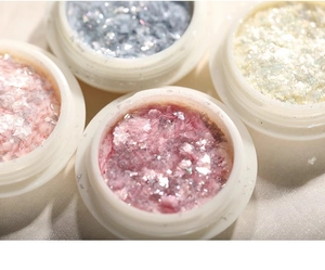 Macro shot of colorful aurora opal flakes in small jars for nail art decoration
