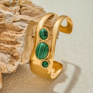 Detail of gold-plated open cuff bangle featuring vertical triple green malachite stones