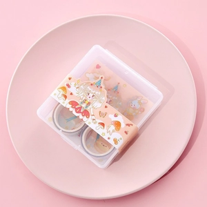 Close-up of decorative floral washi tape set in a pink box on a ceramic tray