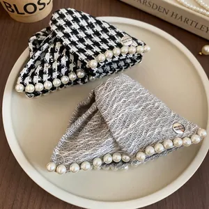 Elegant houndstooth and tweed hair claws with pearls and metal badge in a vintage style