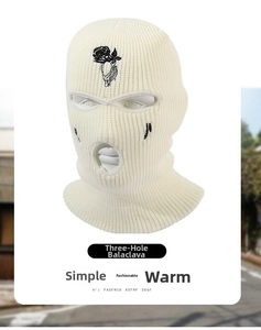 Close-up of black rose embroidery and ribbed texture on off-white knitted 3-hole ski mask