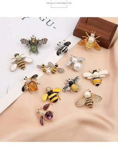 Detailed collection of bee brooches with pearls and zircons on silk background