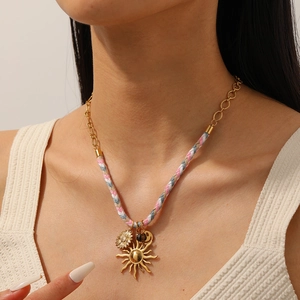 Gold sunflower pendant necklace with colorful braided rope and chain on a model