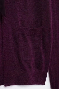 Détail du tissu tricoté violet foncé montrant une poche plaquée latérale soignée