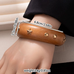 Detail view of retro wooden wide bangle with metal star studs and size specifications
