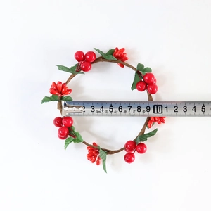 Artificial Christmas wreath candle ring with red berries and green leaves on white background