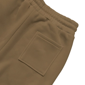 Detalle de pantalón deportivo marrón café con costura en bolsillo trasero y cintura elástica