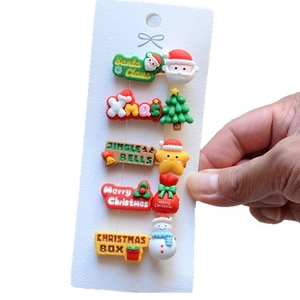 Detail of Christmas hair clip set featuring Santa Claus and reindeer holiday themes