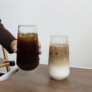 Detailed view of vertically ribbed glass cups filled with iced coffee and latte layers