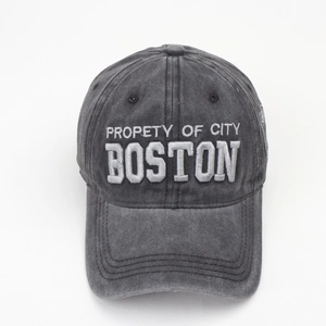 Close-up of washed gray cotton baseball cap with white Boston embroidery and side patch