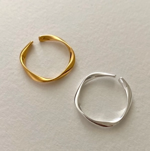 Detailed view of intertwined wave rings in polished gold and silver finishes