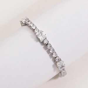 Detailed view of silver tennis bracelet with emerald cut zircon and white gold finish