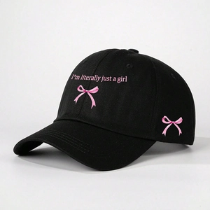 Close-up of a black baseball cap with pink embroidery and cute ribbon details
