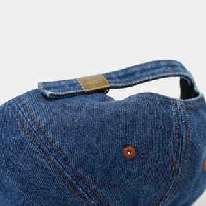 Close-up of vintage denim baseball cap with adjustable metal buckle and contrast stitching