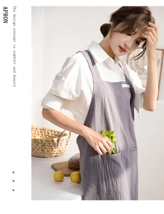 Detail of gray linen apron with convenient front pocket and brand label in a bright studio
