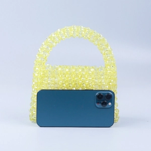 Mini lemon yellow handmade beaded handbag showing scale next to a smartphone