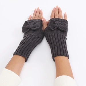 Detail of dark grey knit fingerless gloves featuring a delicate ribbed bow and elastic cuffs