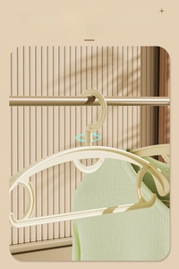 Detail view of the 360-degree rotating hook and non-slip shoulder on the beige hanger