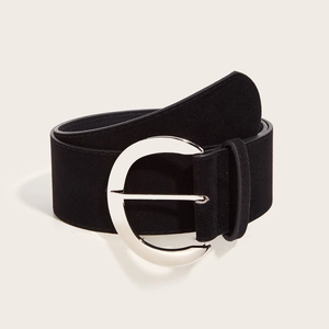 Détail d'une ceinture large en daim noir avec une boucle ronde en métal argenté poli
