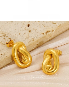Détail de boucles d'oreilles nœud torsadé plaqué or 18K sur pierre et fond en soie