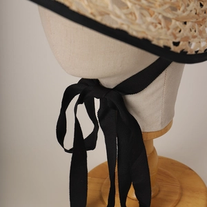 Handwoven raffia lolita straw hat with wide black grosgrain ribbons and hollow brim
