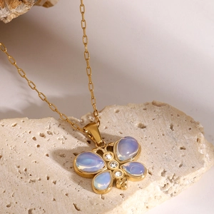 Macro shot of gold-plated butterfly necklace with blue opal stones and zircon accents