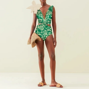 Detail of green floral one-piece swimsuit featuring a deep V-neck and 3D flower accent
