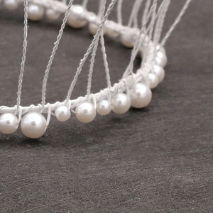Close-up of white wire frame cake topper base with elegant pearl bead decorations