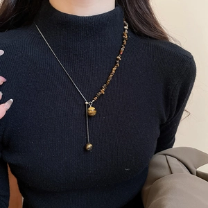 Tiger eye stone pendant necklace on a black sweater showing vintage luxury style
