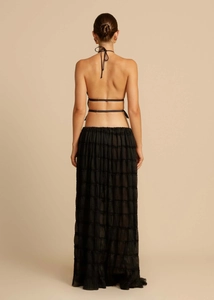 Back view of black halter top with thin ties and tiered ruffled chiffon maxi skirt