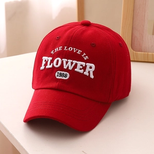 Gros plan détaillé de la broderie 3D blanche épaisse sur une casquette en coton rouge