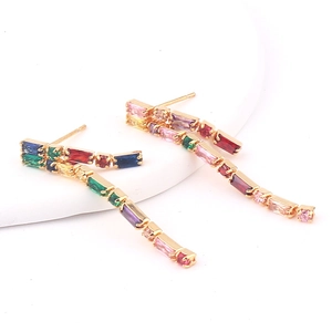 Macro detail of gold tassel earrings with colorful rectangular rainbow crystals