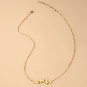Detailed macro view of gold heartbeat necklace with horse pendant and lobster clasp