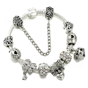 Macro shot of silver charm bracelet with Love heart pendant and crystal beads