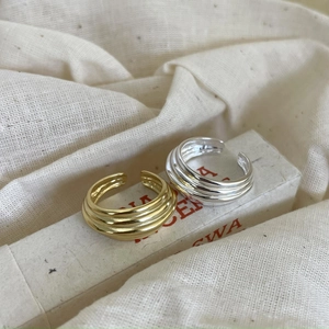 Detail of 925 sterling silver quilted rings in gold and silver on vintage book
