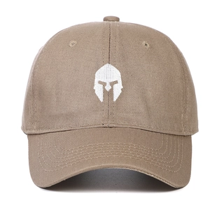 Close-up of a khaki baseball cap featuring white embroidered Spartan helmet design