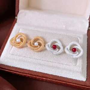 Vintage knotted earrings with pearls and red beads in a leather jewelry box