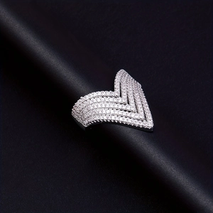 Macro shot of V-shaped silver ring with micro-paved diamonds on black background