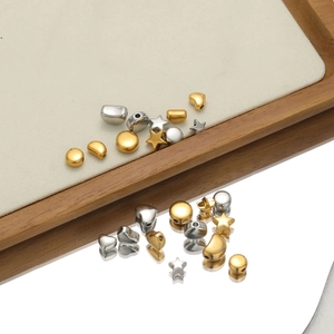Macro view of gold and silver geometric star and heart metal charms for DIY jewelry making