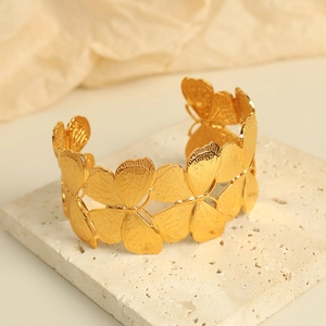 Elegant gold butterfly open cuff bracelet with hollow design on minimalist stone background