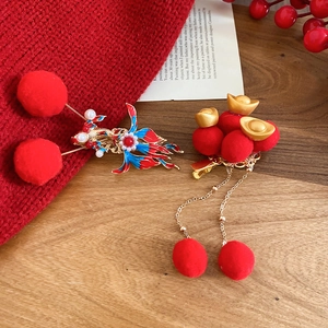 Close-up of New Chinese style hair clip with red pom-poms, gold ingot and long tassels
