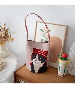Detailed close-up of canvas bucket bag featuring a cute cat with a red striped hat